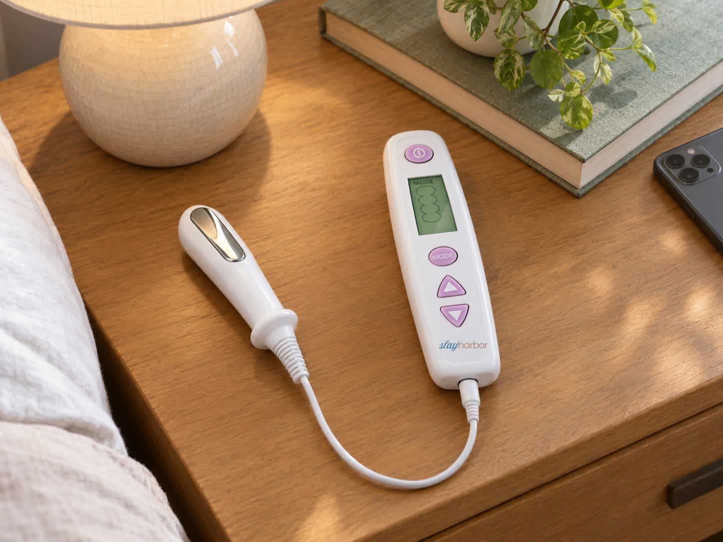 The trainer controller, probe and USB cable on a bedside table, phone face down